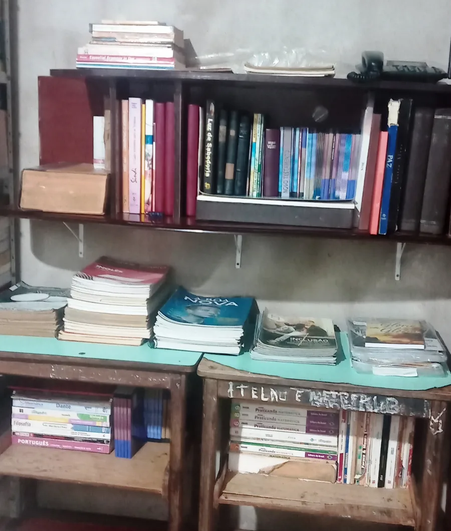 Livros escolares empilhados sobre a mesa de leitura da biblioteca