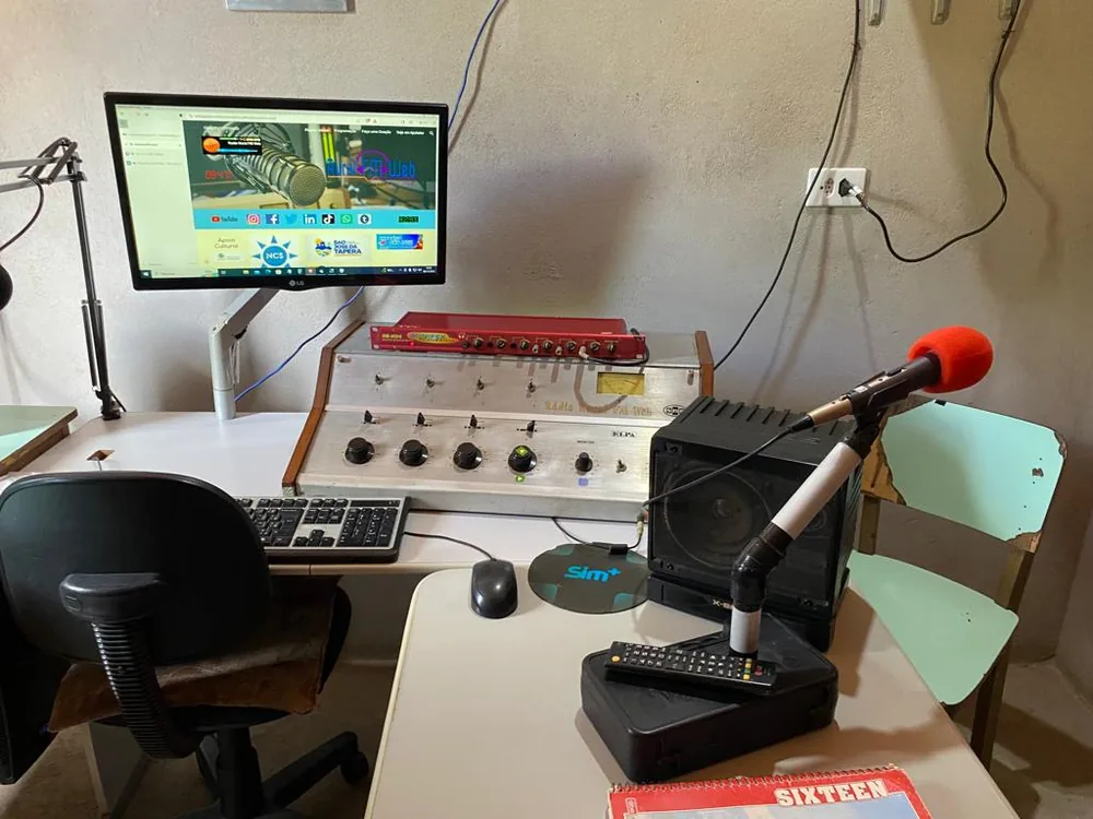 Estúdio da Rádio Rural FM Web, com mesa de som, microfone e computador